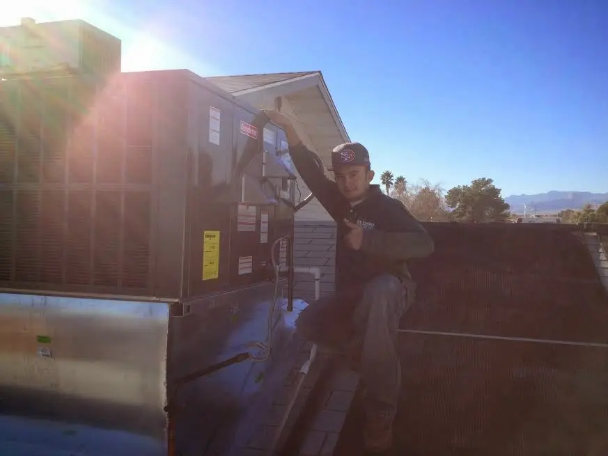 HVAC technician performing Heat Pump Repair on a rooftop unit in Perry